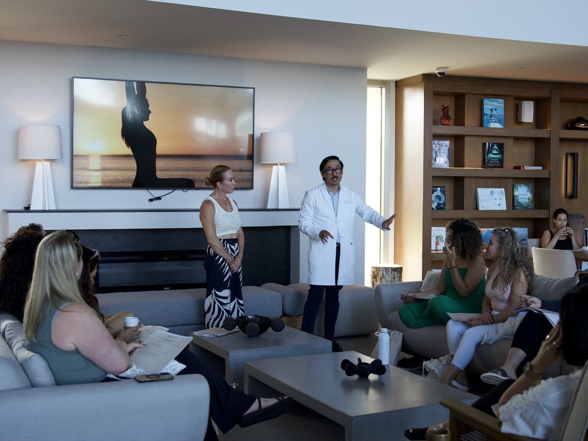 A physician in a white coat leading a talk for the group