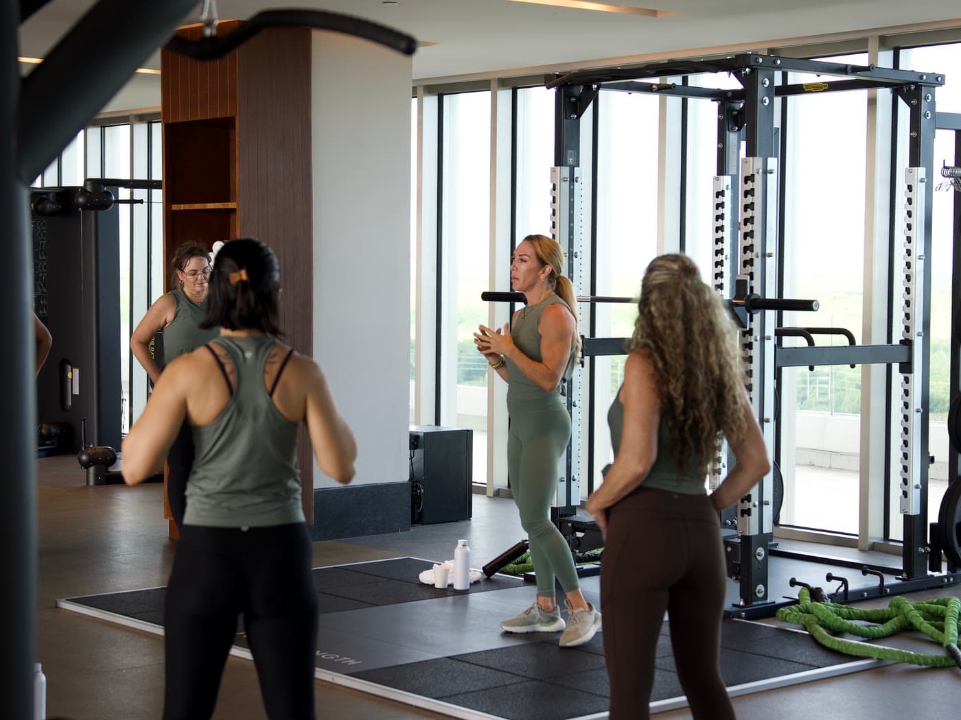 Ryall coaching a group of guests through a strength class in a gym overlooking the jungle