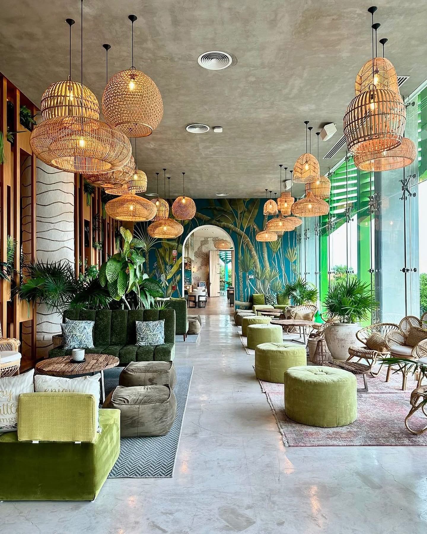 The open lobby at Palmaïa, with rattan lamps and green velvet seating